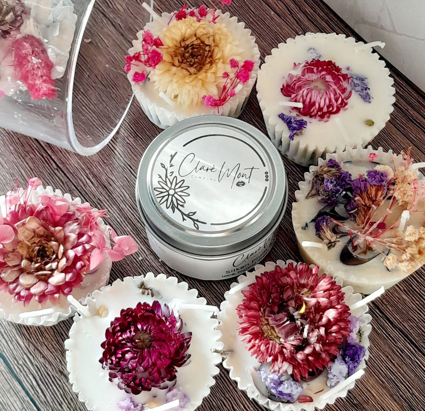 Boxes of Bougie Nights Firelighters, each with a unique floral decoration on top, displayed alongside a tin container with the brand name.