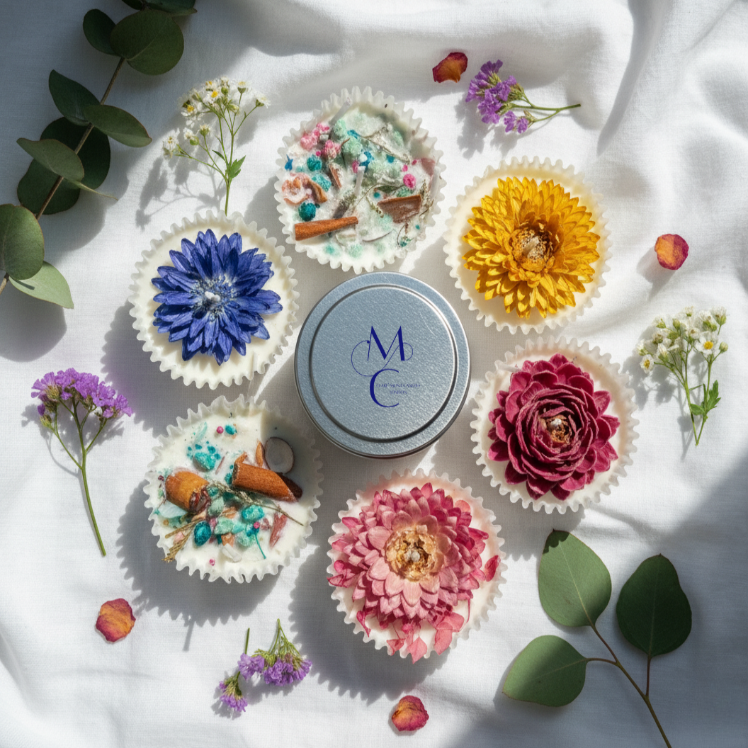 Decorated firelighters with floral designs on a white surface with a 'MC' branded container.