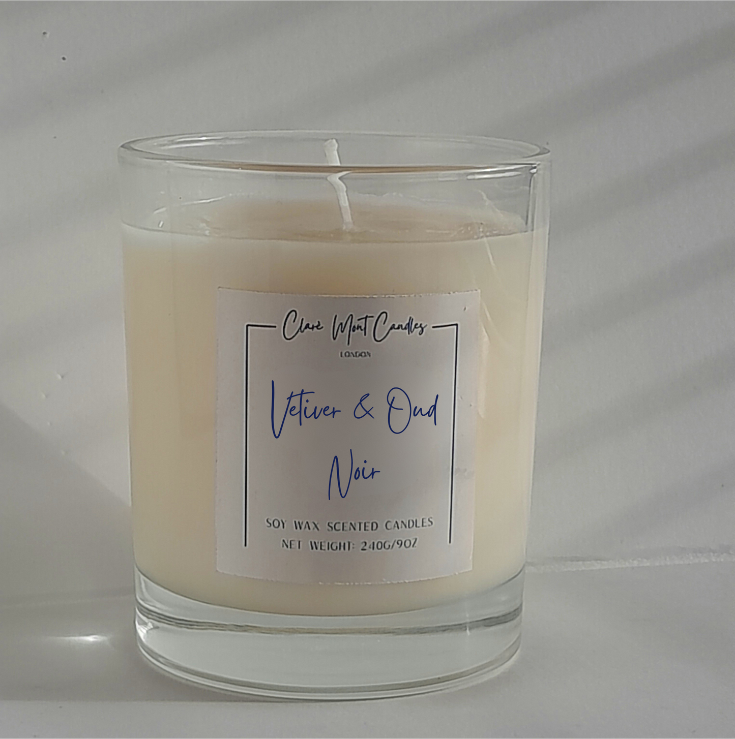 Vetiver & Oud Noir candle beside incense, a notebook and soft shadows — deep and meditative.