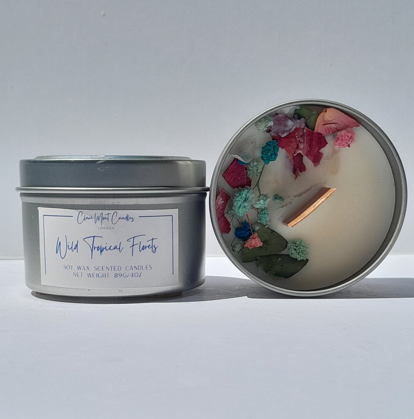 Candle in a tin with floral elements on a white background