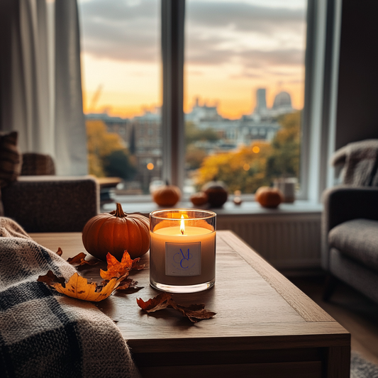 A lit Clare’ Mont Candle in a London living room styled with autumn décor — pumpkins, warm textiles, and golden evening light