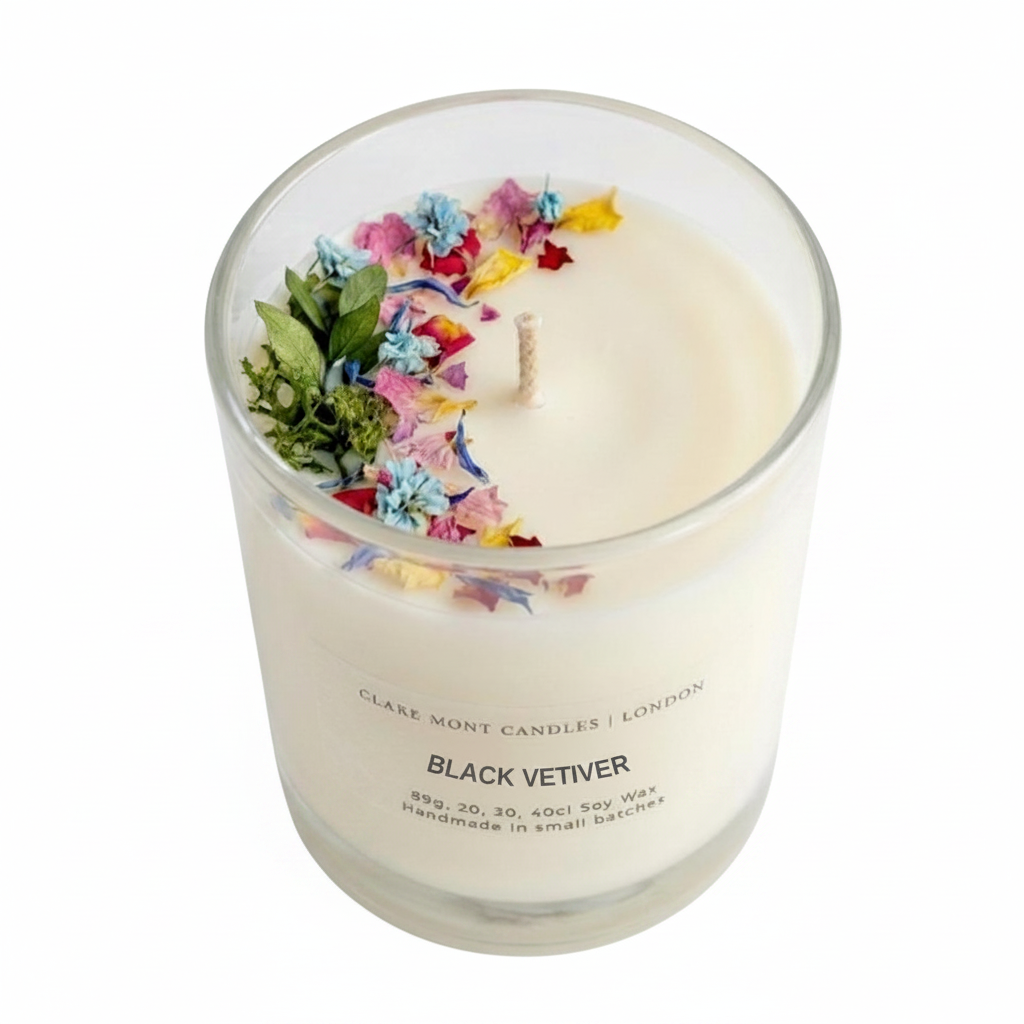 black Vetiver hand poured Clare' Mont Candle with floral and greenery elements in a glass container on a white background