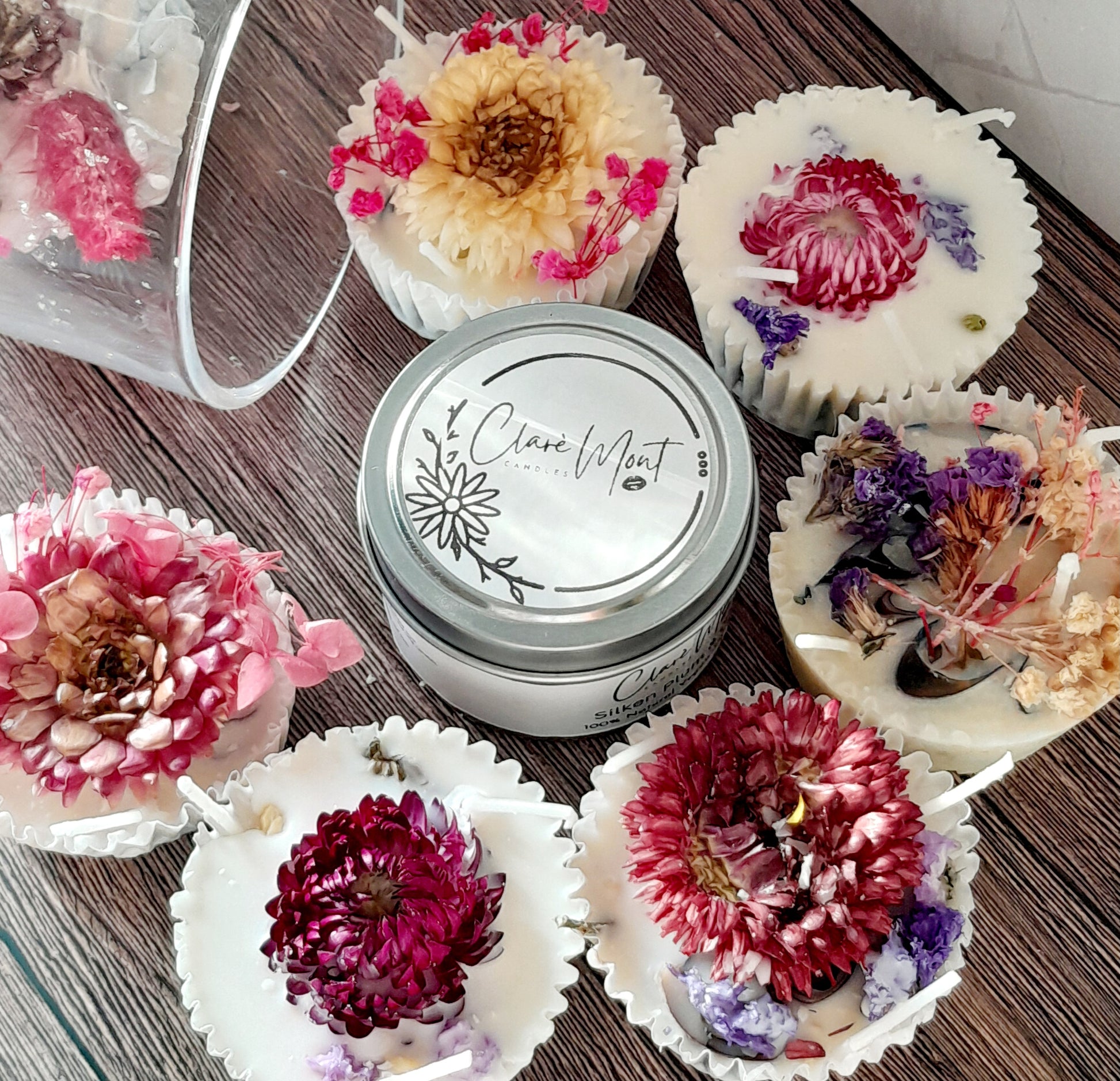Boxes of Bougie Nights Firelighters, each with a unique floral decoration on top, displayed alongside a tin container with the brand name.