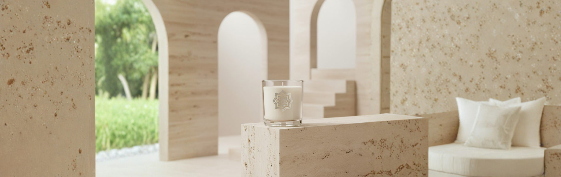 Beige interior with a candle on a table and a couch in the background