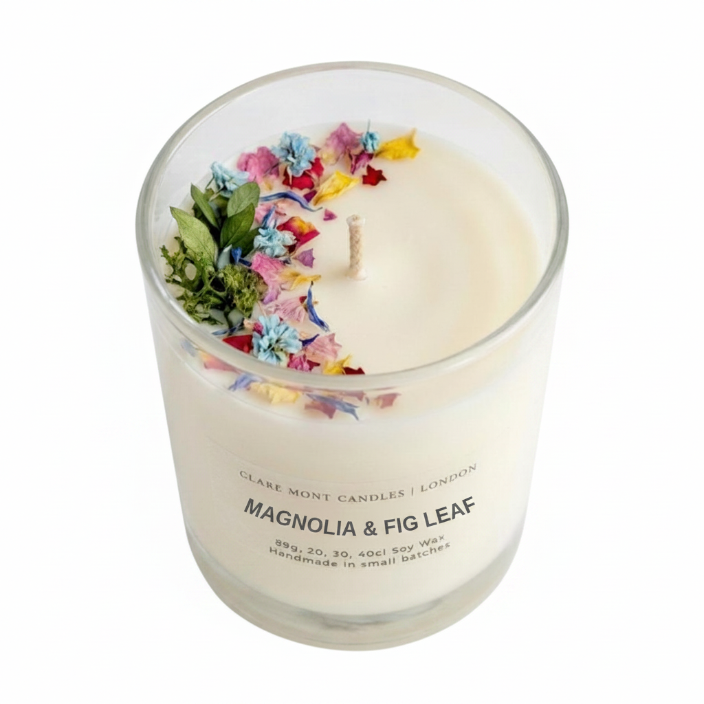 Magnolia & Fig Leaf hand poured Clare' Mont Candle with floral elements in a glass jar on a white background