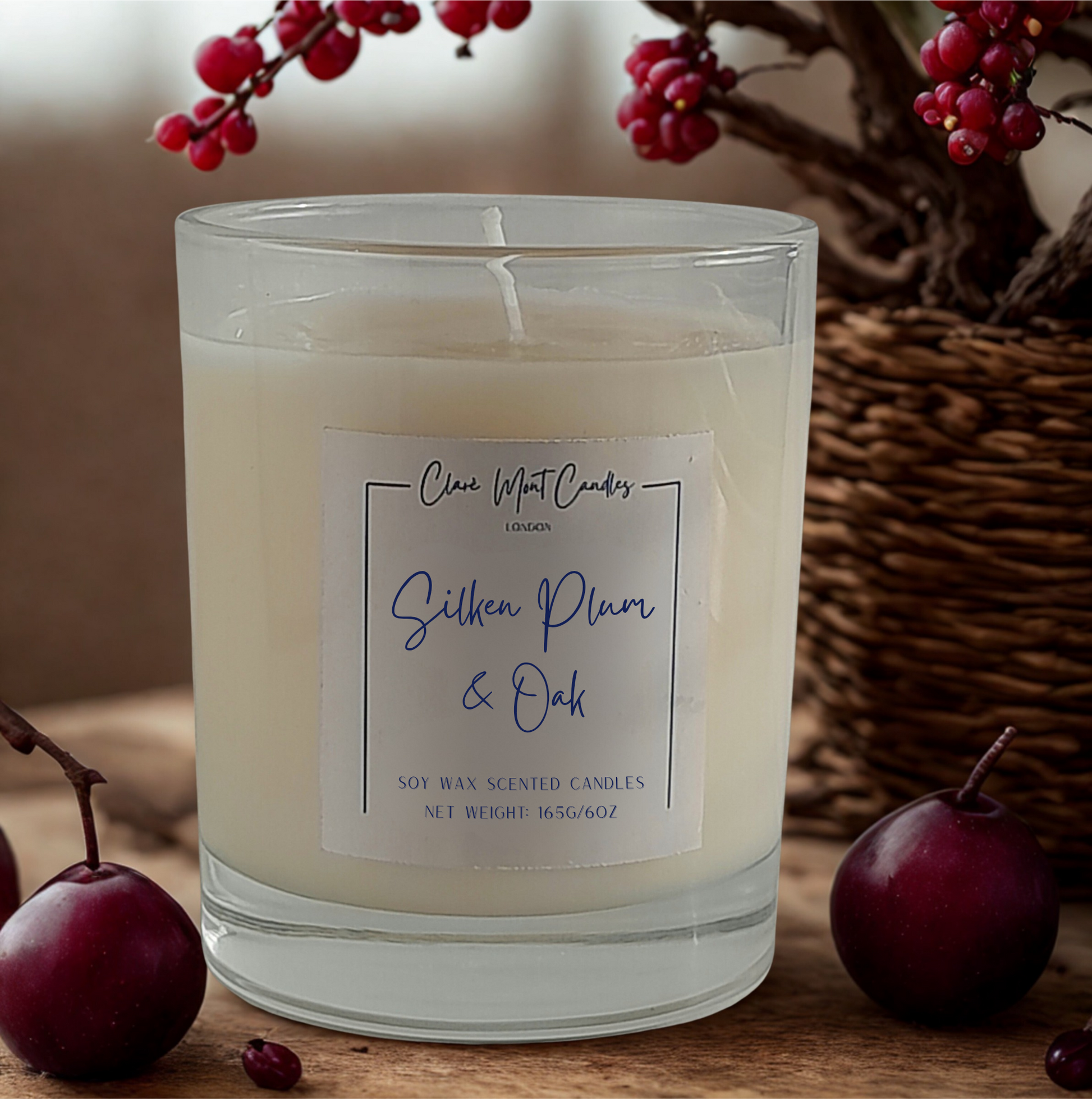 Scented candle with a label on a wooden surface with berries and an apple.