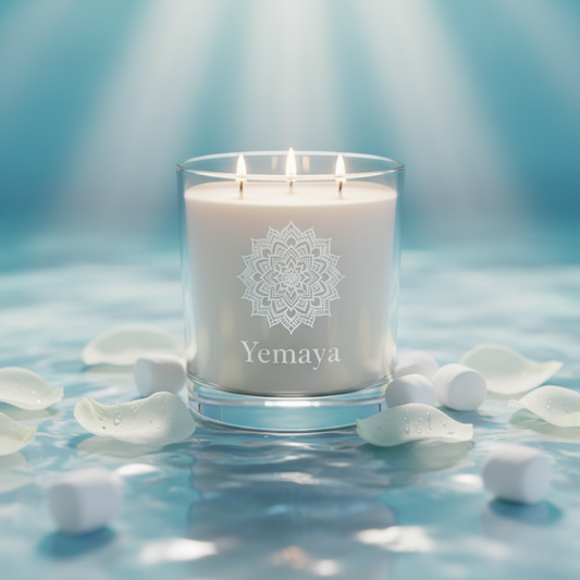 White candle with 'Yemaya' branding on a blue background with petals
