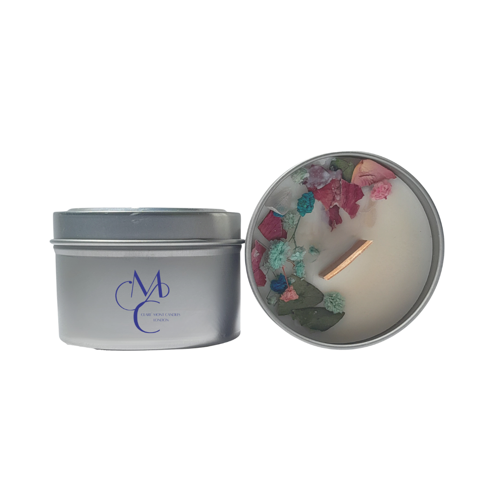 Silver candle tin with a decorative candle inside on a white background