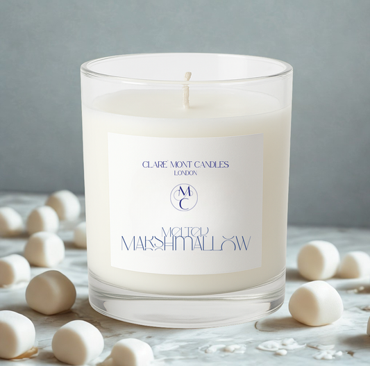 Clare` Mont Candle with a label on a table with marshmallows