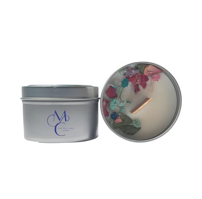 Silver candle tin with a decorative candle inside on a white background