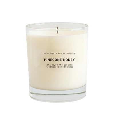 Candle labeled 'Pinecone Honey' by Claremont Candles on a white background